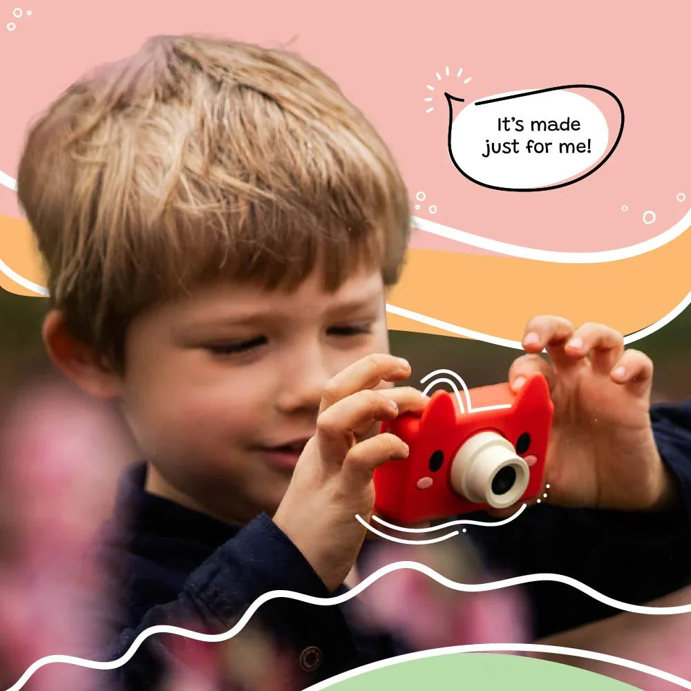 Child holding and using the kiimento Model C Fox kids camera outdoors with a joyful expression