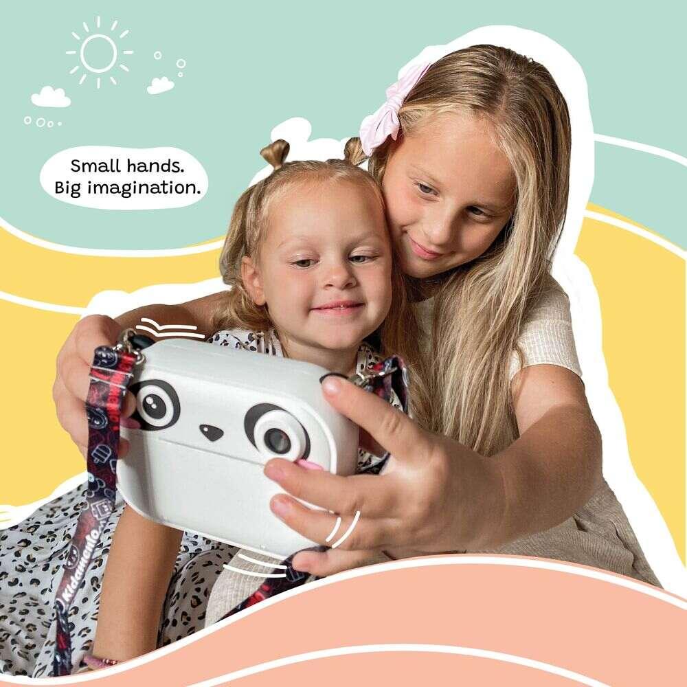 Two girls taking a selfie with kiimento Model P Panda kids camera, showing playful bonding moment with colorful background.
