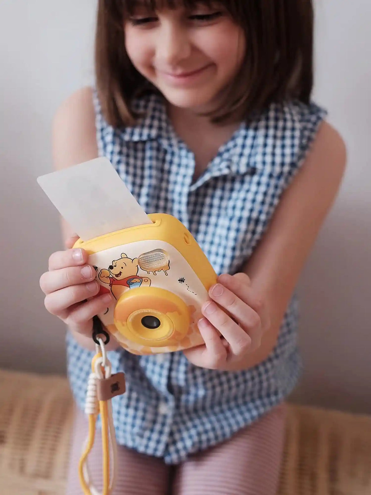 Girl holding kiimento Disney Winnie the Pooh Print Pro Camera Model P2 printing a photo – kids instant print camera
