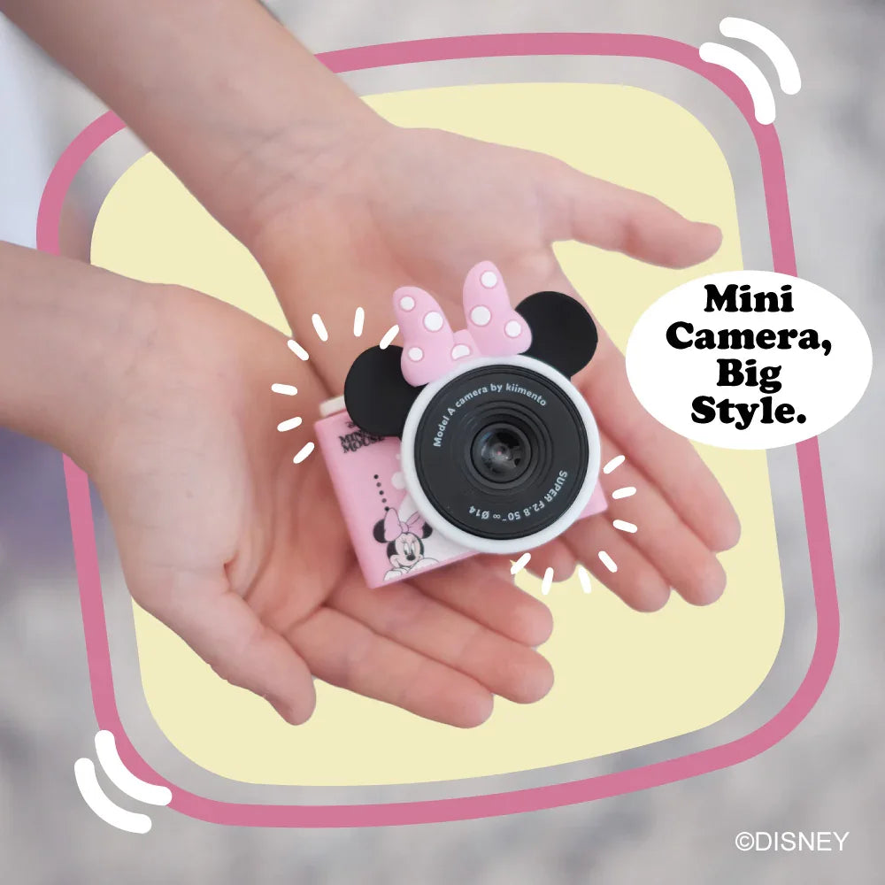 Minnie Mouse mini camera with pink bow and ears holding by kid's hands.