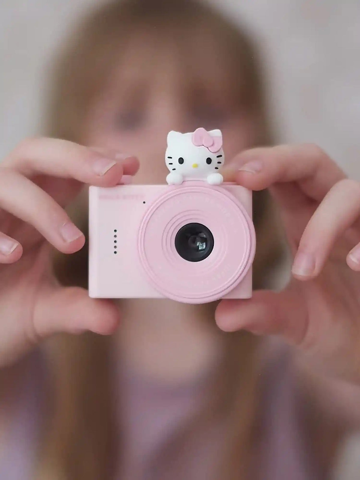 Girl holding kiimento Sanrio Hello Kitty Mini Camera Model A outdoors – pink Hello Kitty mini kids camera