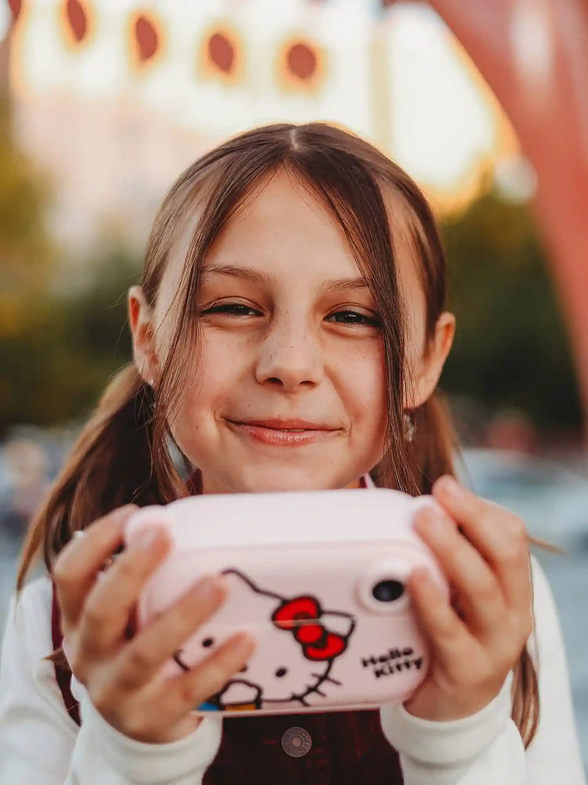 Girl using kiimento Sanrio Hello Kitty Print Camera Model P – pink Hello Kitty kids instant print camera